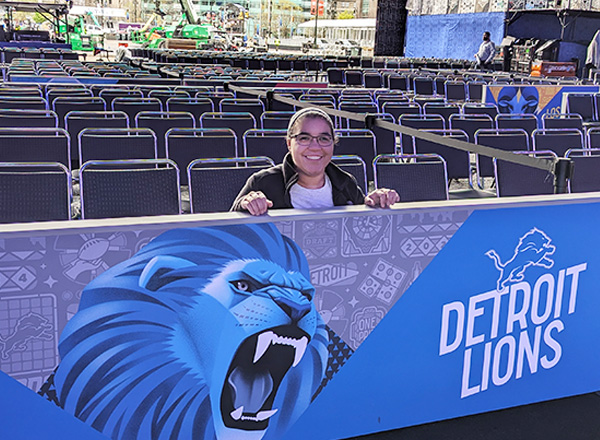 Kayla Kerr is standing behind the Lions sign.