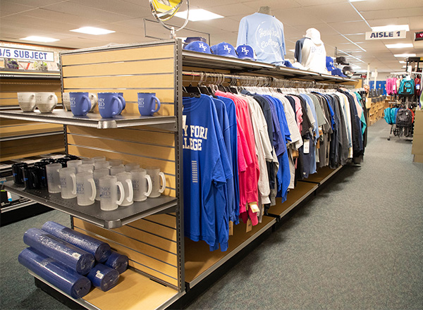 One of the aisles inside the College Store full of shirts, hoodies, HFC mugs, and other merchandise for purchase.