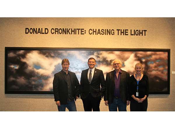 Photographer Donald Cronkhite, HFC President Russell Kavalhuna, HFC art professor Steve Glazer, and HFC School of Liberal Arts Associate Dean Cynthia Stiller stand in front of one of Cronkhite's photos. 