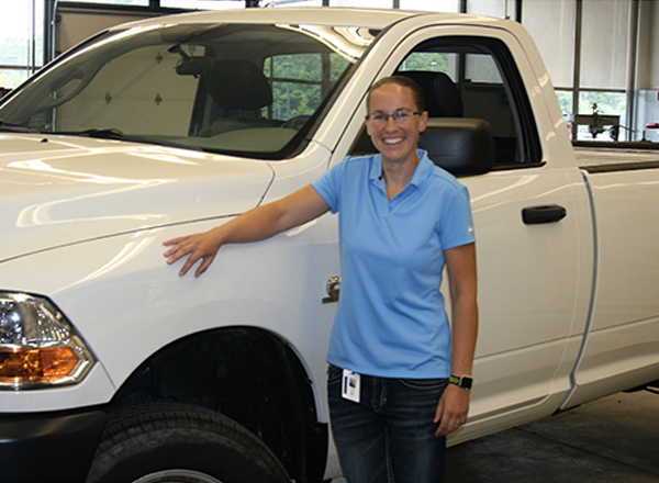 Ashley Smith, HFC's first female automotive faculty member, poses with a pick-up truck