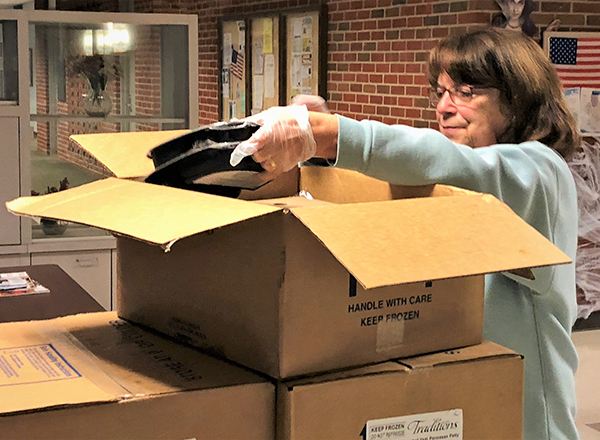 HFC alumna Barb Hayes packs meals for senior citizens at Sisson Manor in Dearborn. 