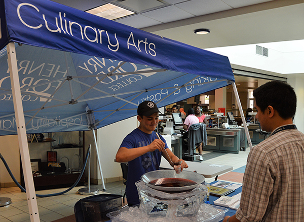 A student samples the offerings of HFC's Culinary Arts program at Welcome Back Days. 