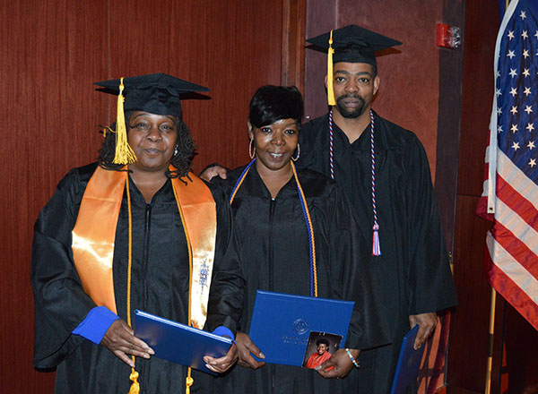 Three students at their commencement ceremony