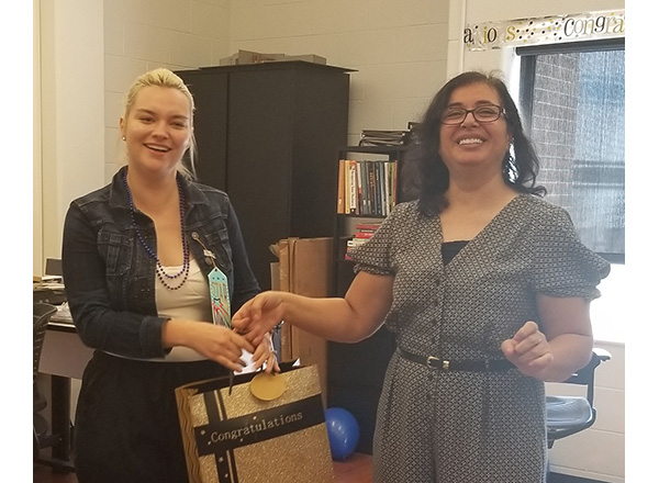HFC Interior Design student Hiam Yissine (right) gives HFC alumna Allison Jones (left) a gift bag after learning she won 2nd place in the NKBA Student Design Competition.