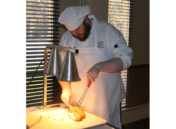 HFC student Robert Thacker carves meat during a buffet