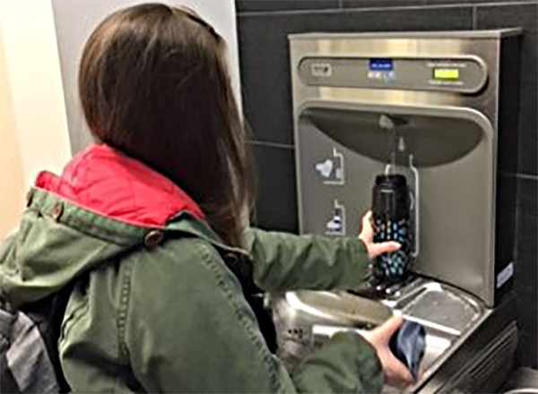 Photo of woman filling her water bottle at the hydration station 