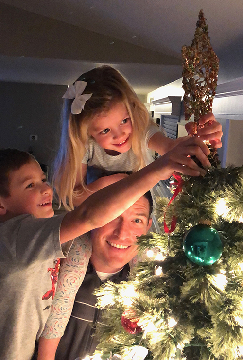 Russ with his children, trimming the tree.