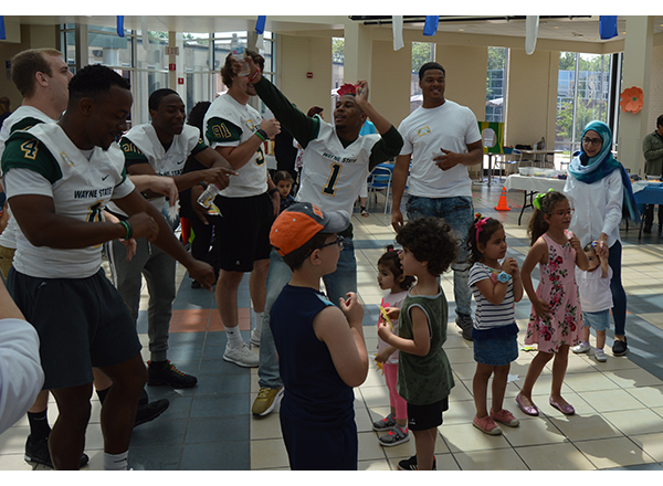 Members of the Wayne State University football team dance along with kids at the 4th Annual Family Literacy Event. 