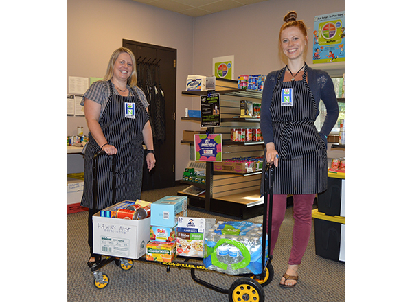 HFC Student Activities Associate Mandy Earl and HFC student Lucy Smith catalog the food items donated to the Hawks' Nest. 