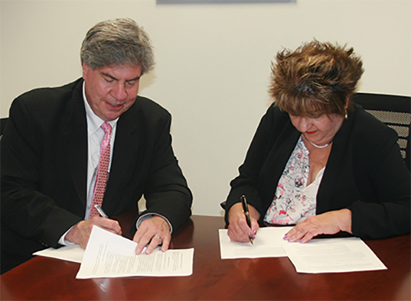 Dr. Michael Nealon (left), HFC Vice President of Academic Affairs, and HFC AFO President Lynn Boza (right) sign the memorandum of agreement. 
