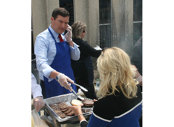 Multi-tasking: HFC President Russell Kavalhuna takes a quick call while serving burgers.