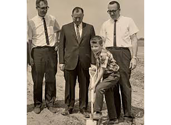 The 1966 groundbreaking ceremony of MCCC. From L to R: MCCC board member Fred Gruber, State Rep. Ray Kehres, Kevin Campbell (digging), and Dr. Ronald Campbell, MCCC's founding president. Campbell's son was 8 at the time of the groundbreaking and helped h
