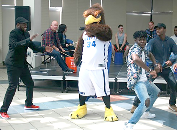 Hawkster and students dancing
