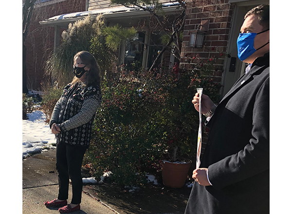Because the pandemic is making it impossible to have a farewell party for Trustee Mary Lane (left), HFC President Russell Kavalhuna (right) presented her with a gift at her home in Dearborn. People affiliated with HFC and Dearborn Public Schools, as well