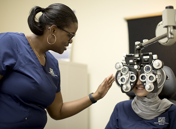 Ophthalmic technician in the HFC lab learning to conduct an eye exam