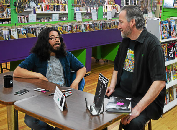 HFC alumni (from left to right): Award-winning writer Saladin Ahmed and Dan Merritt, co-owner of Green Brain Comics in Dearborn, at one of Ahmed's previous signings. 