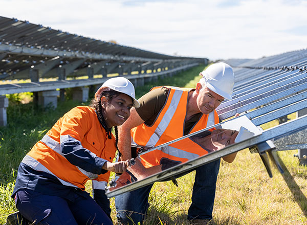 Senior Engineer and apprentice working together on solar farm installation.