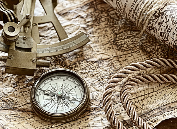 Image of sailing tools of the 15th century: sextant, compass, map, rope.