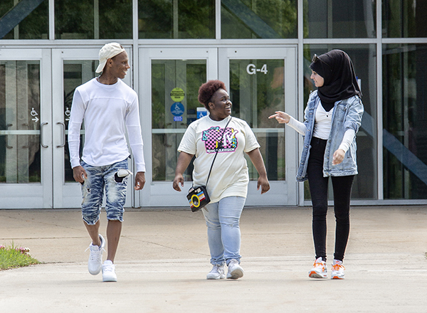 Image of three students walking in front of the Health Careers building