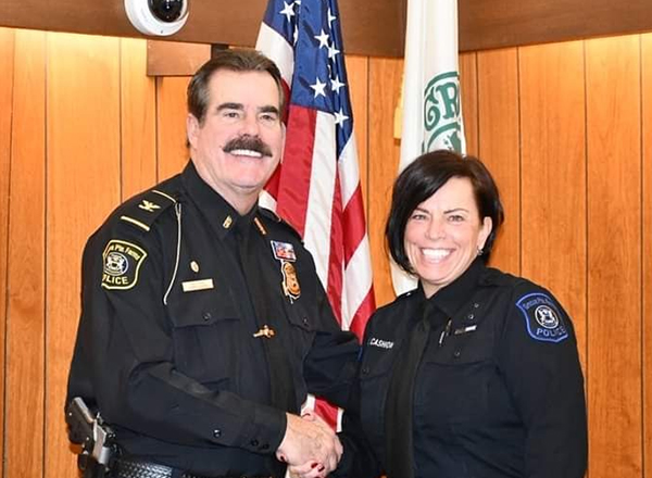 Grosse Pointe Farms Public Safety Director Daniel Jensen shakes hands with HFC alumna Veronica Cashion. After suffering many severe injuries in an accident several years ago, Cashion returned to active duty as a police officer. Swearing her in was Jensen
