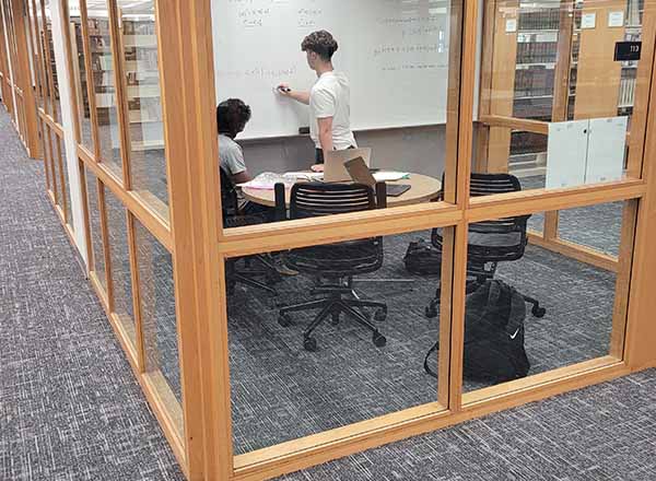 Two HFC students work together in a private study room in the Eshleman Library. 