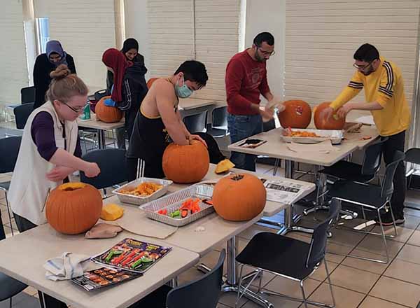 A group of students work diligently on their pumpkins in the Student & Culinary Arts Center. 