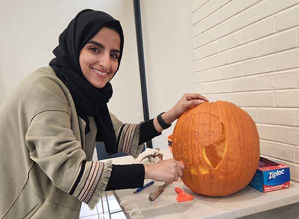 Muna Saleh puts the finishing touches on her pumpkin.