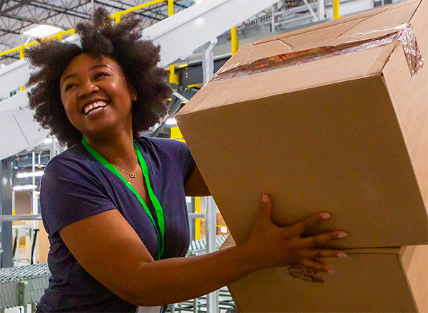 Smiling young woman loading boxes in a warehouse
