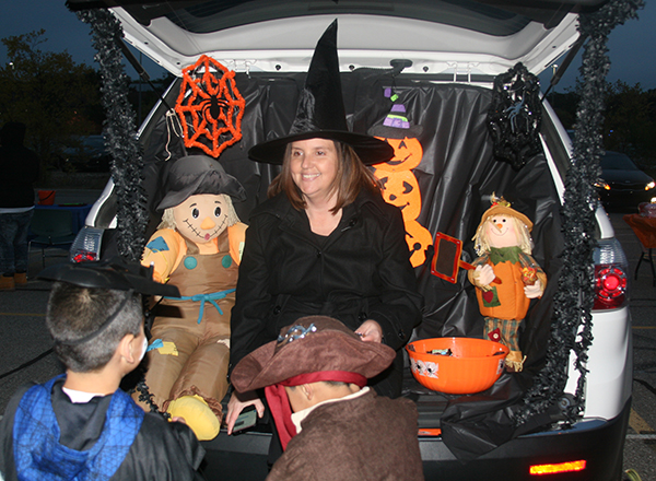HFC Assistant Director of Financial Aid Stephanie Latzke, dressed as a witch, hands out treats to kids at a previous Trunk or Treat event.