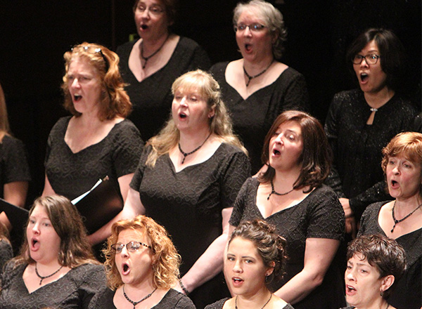 A closeup of the female singers in the Renaissance Voices singing at a performance.