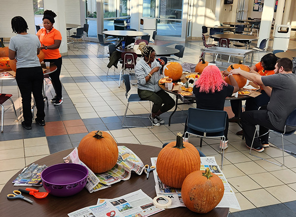 HFC students and employees work happily on their pumpkins in the John McDonald Student & Culinary Arts Center.