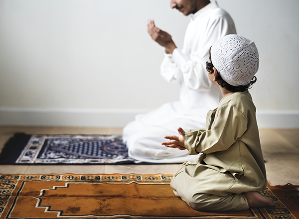 A parent and child at prayer during Ramadan.