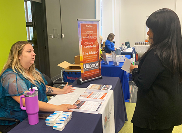 Ulliance employee speaking with an HFC employee at a benefit fair.