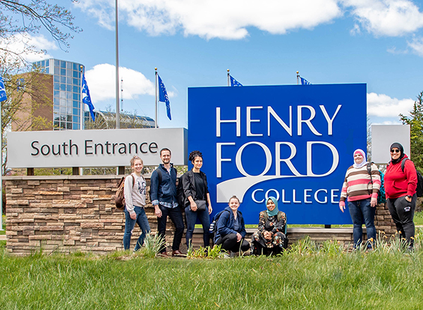 HFC students outside campus main entrance sign