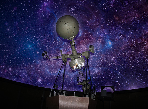 The Hammond Planetarium with a galaxy background.