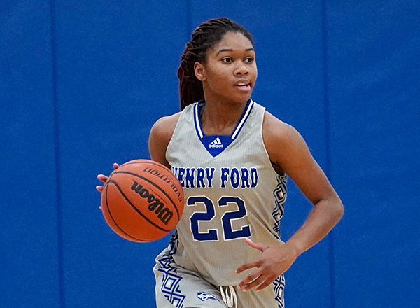 Woman basketball player with a basketball looking away.