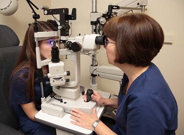 A female Ophthalmic Tecnician checking out a female patients eyes.