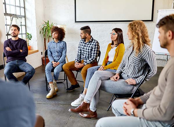 A group of people sitting on chairs in a circle.