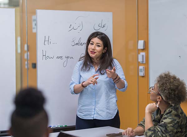 A woman standing in front of a white board.