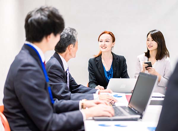 A group of people sitting around a desk.