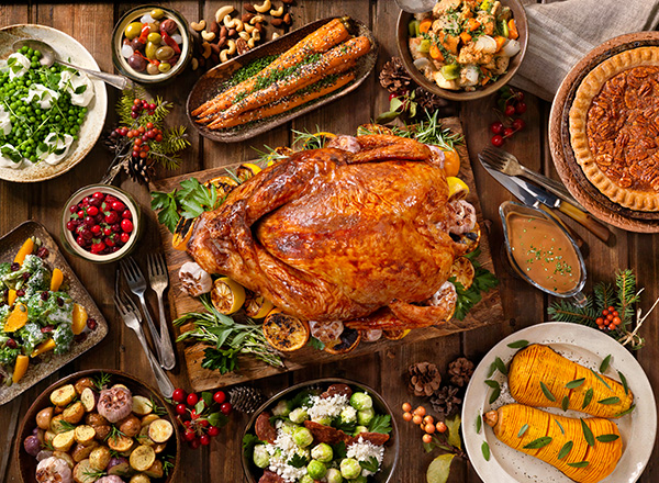 Holiday buffet spread of turkey, squash, pie, veggies.