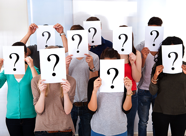 Diverse college students with white sheets of paper in front of their faces and a big question mark on the paper.