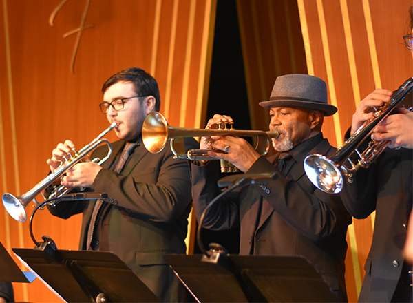 Musicians playing the trumpet at a concert.