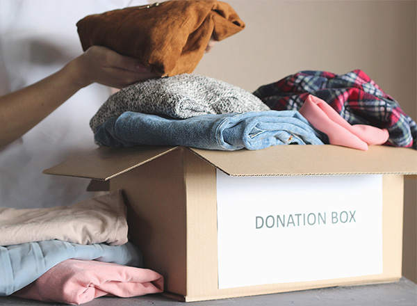 Volunteer puts donation items in a box.