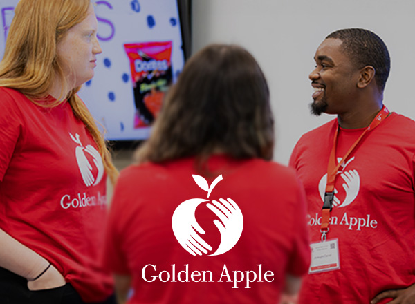 Golden Apple employees in red shirts chatting.