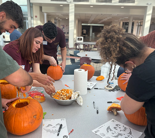 International students in the process of carving their pumpkins.