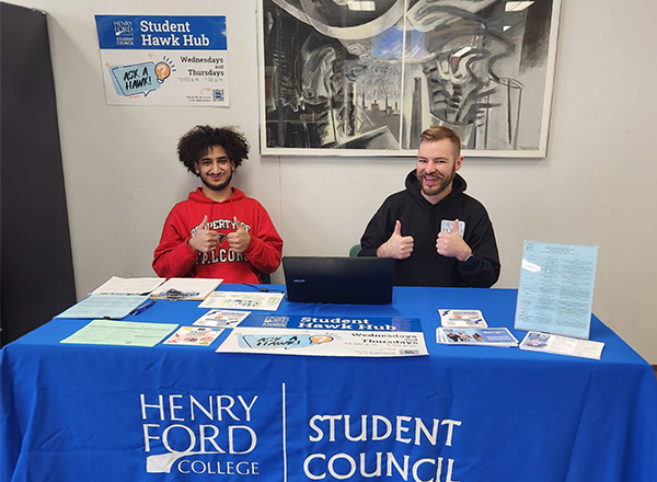 Henry Ford College Student Council members sitting at a table with helpful handouts for students. 