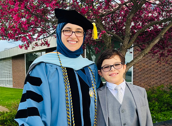 Asia Mohamed Al-Jalal in her graduation gown with her 9 year old son at her side.